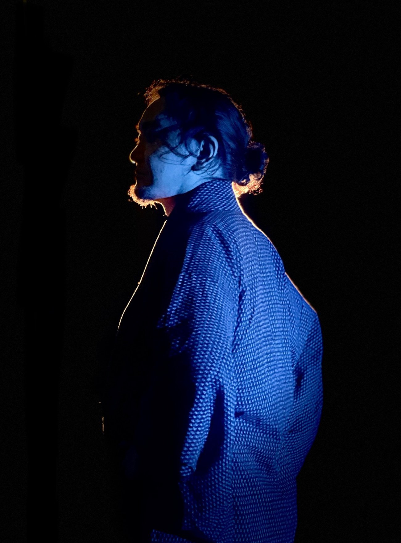 Blue rim-lit profile portrait on black, lit by Keith Ingram DoP