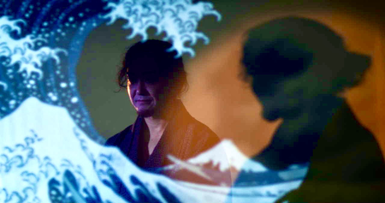 The Great Wave projected over a performer — Scottish Opera film, cinematography by Keith Ingram