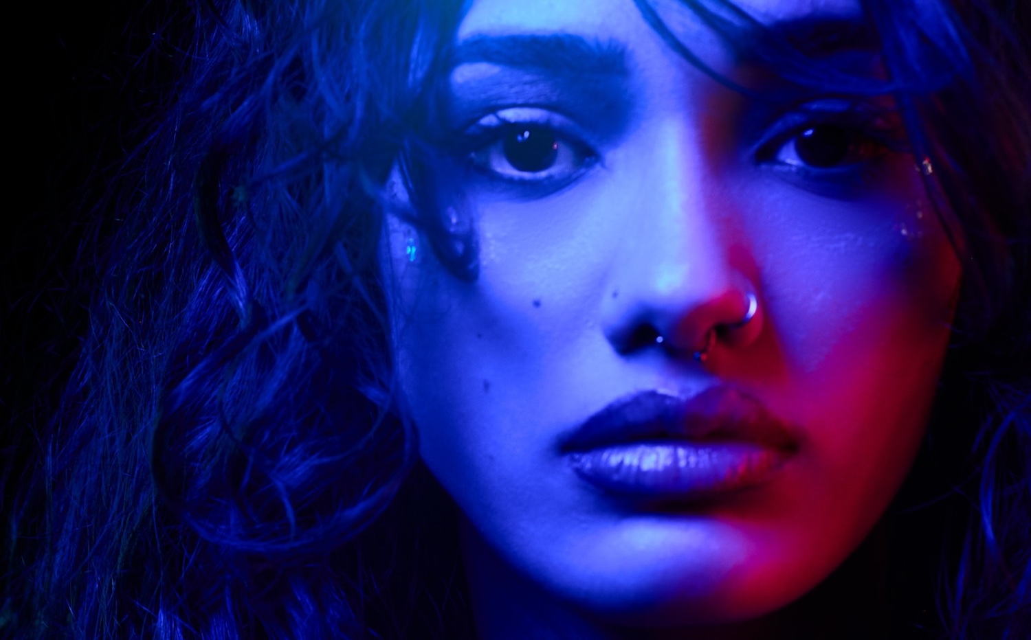 Close-up neon portrait in blue and red, Scottish Opera, shot by Keith Ingram