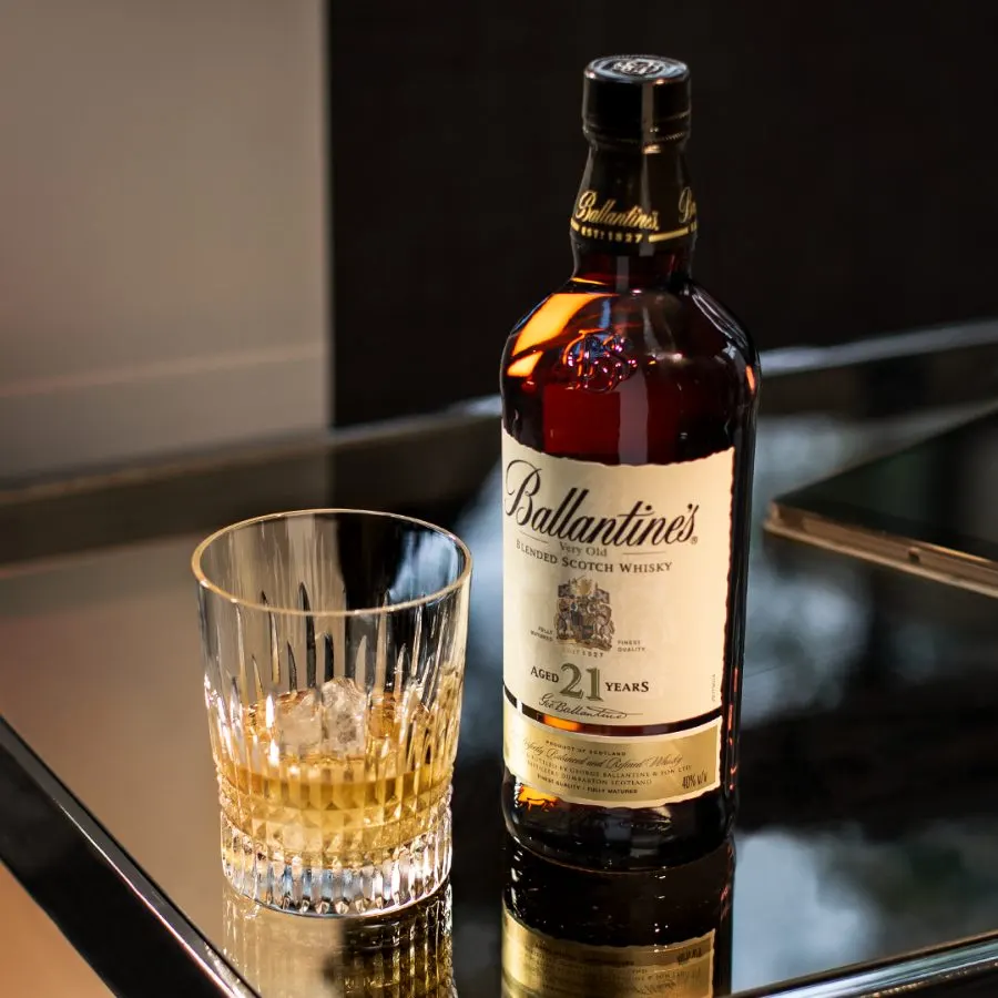 Ballantine's 21 bottle and cut-glass tumbler, warm product lighting